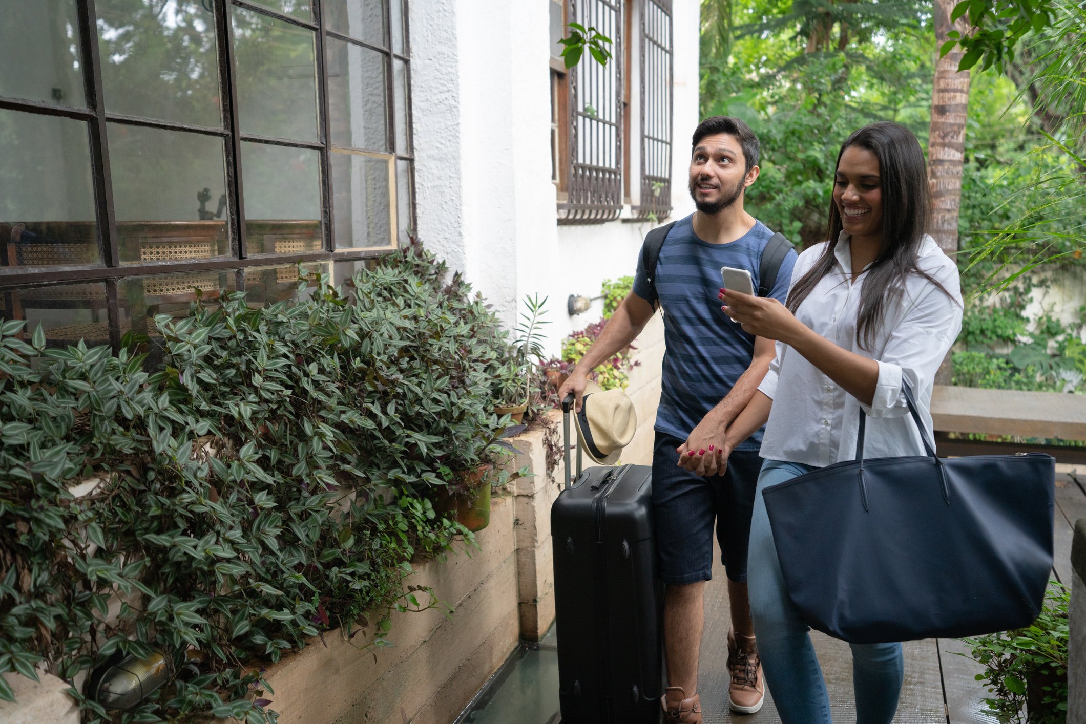 Young people arrive at a B&B with their luggage.