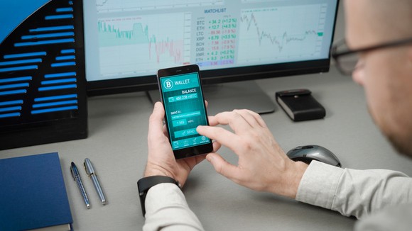 Person checking phone at desk.