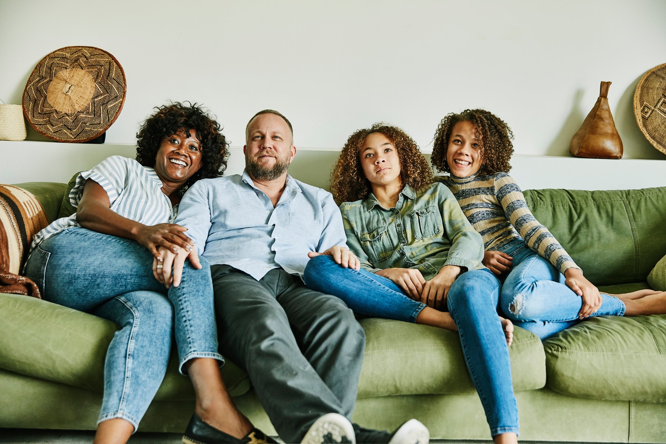 A family sitting on a couch.