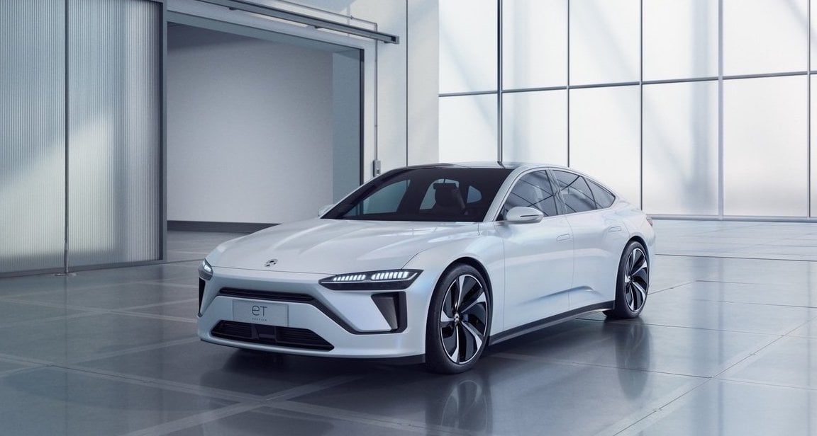 A white Nio ET7, a sleek upscale electric sedan.