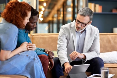 A banker sitting with two clients