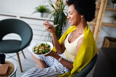 a woman eating a vegetable medley