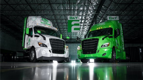 Two hybrid semis painted in Hyliion's green and white colors.