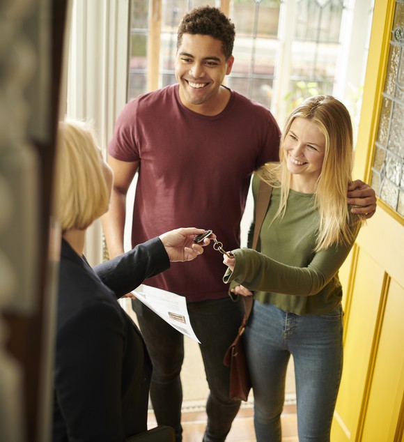 Two people getting the keys to their new rental.