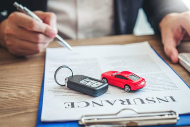 Man signing a car insurance policy