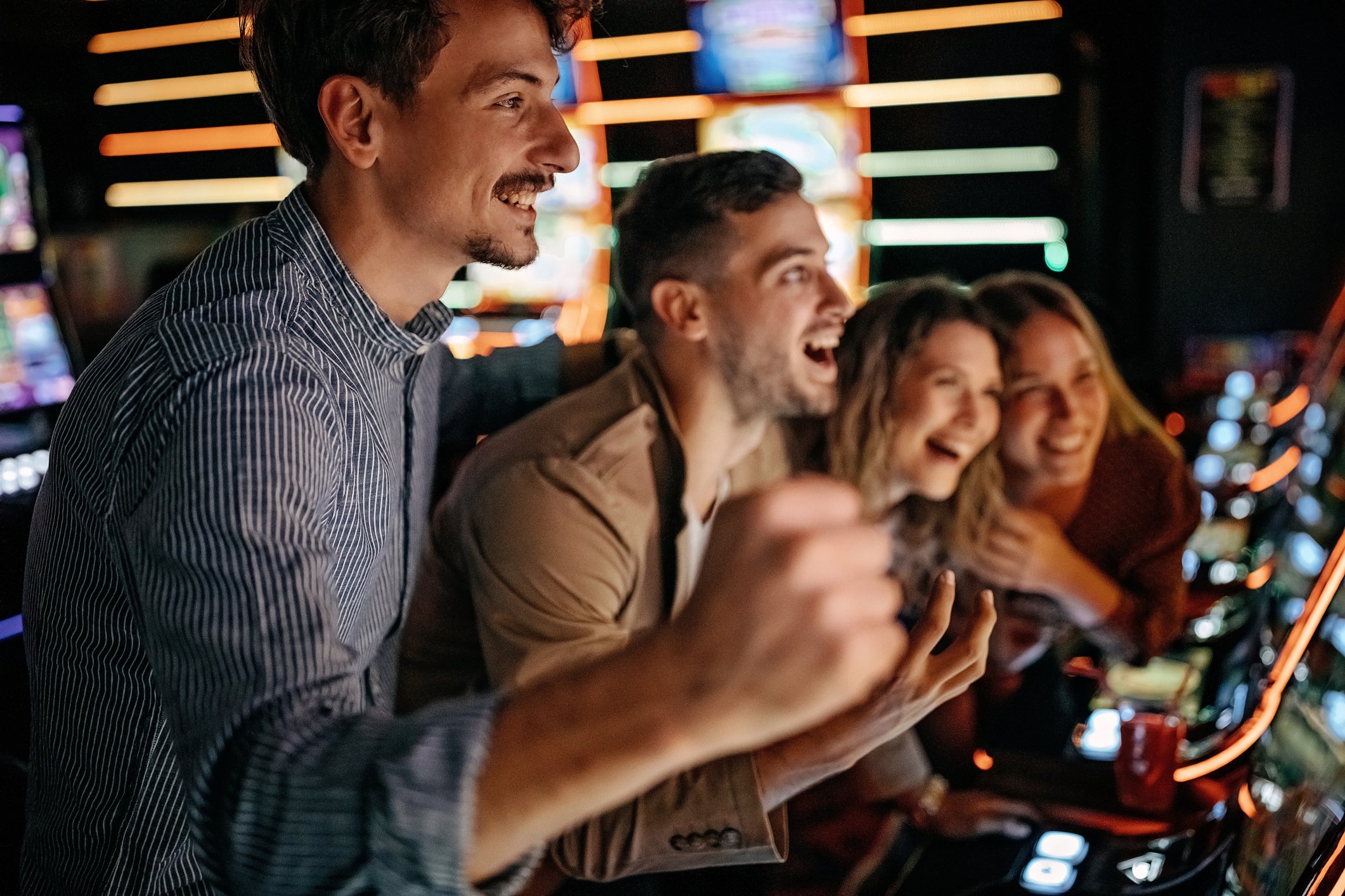 A group of people play slot machines in a casino.