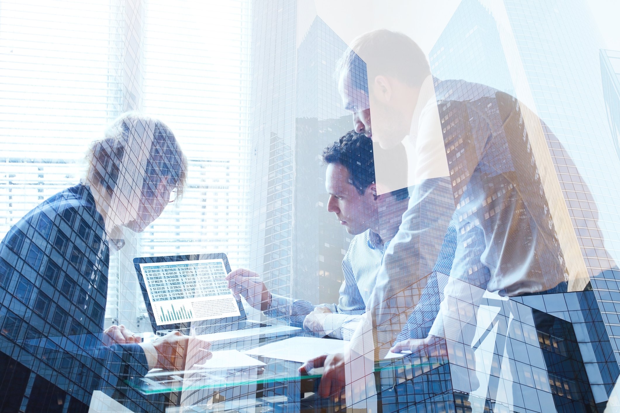 Business people huddled around a computer monitor