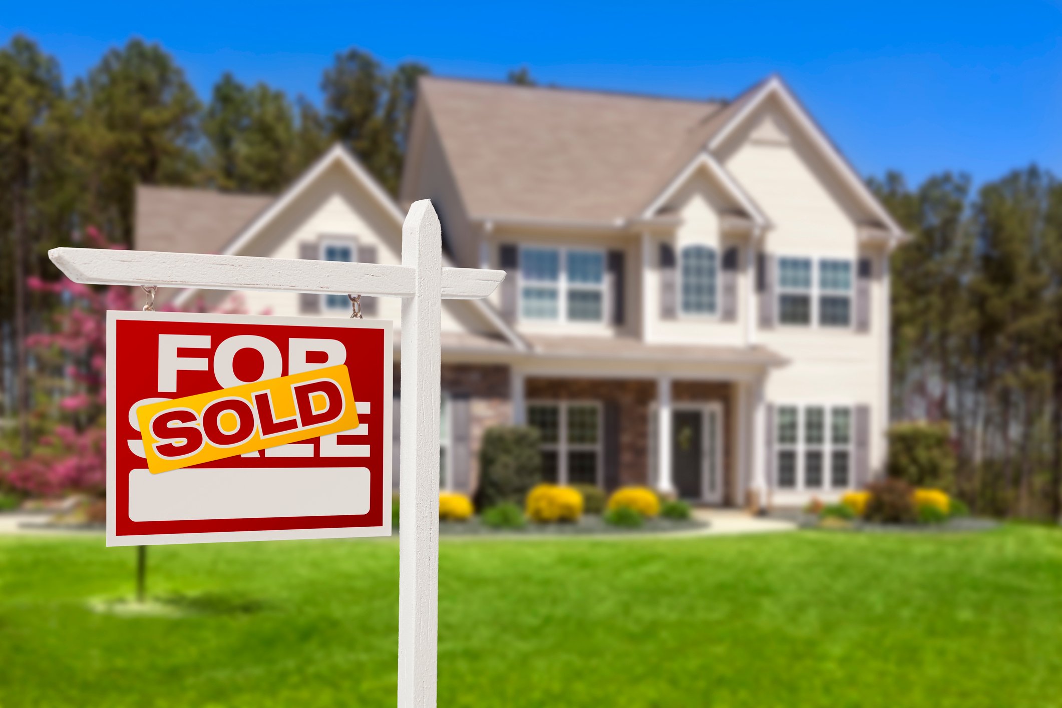 House with sold sign in front.
