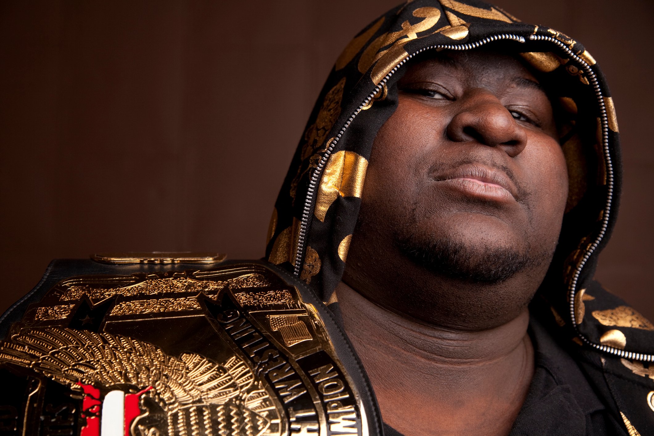 Wrestler holding a championship belt.