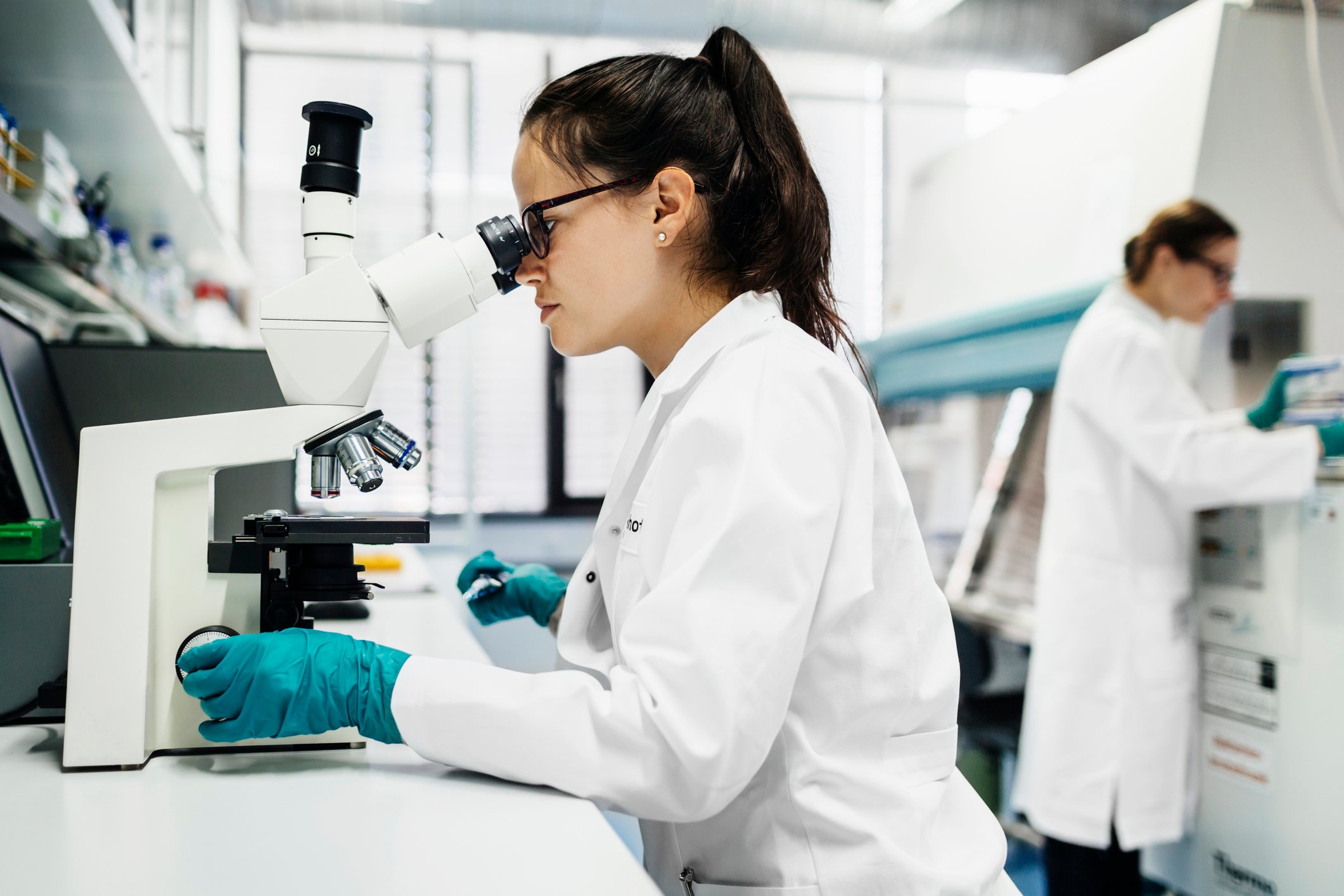 Scientist using a microscope in a laboratory.