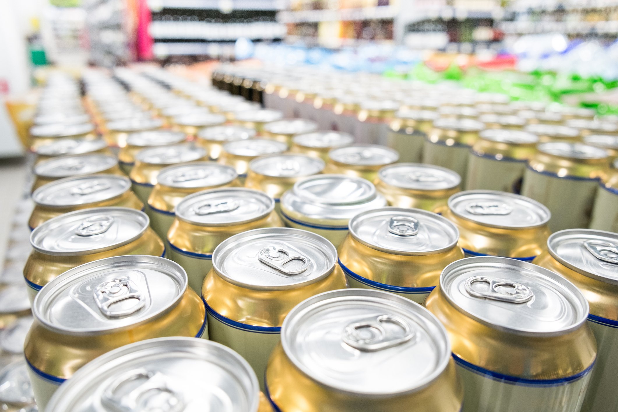 Canned beverages in a grocery store with shelving visible in the background.