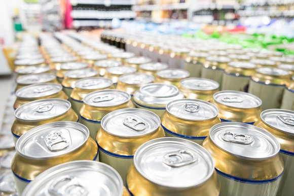 Canned beverages in a grocery store with shelving visible in the background.