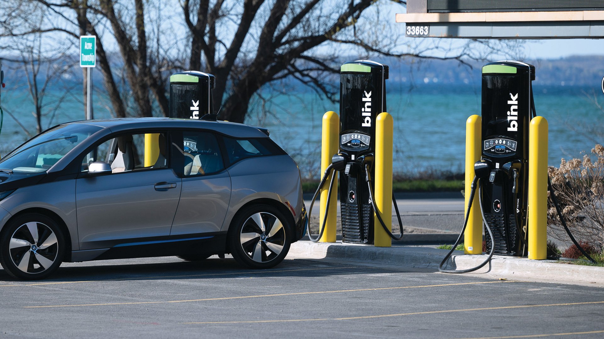 Electric vehicle at Blink Charging station with lake in background.