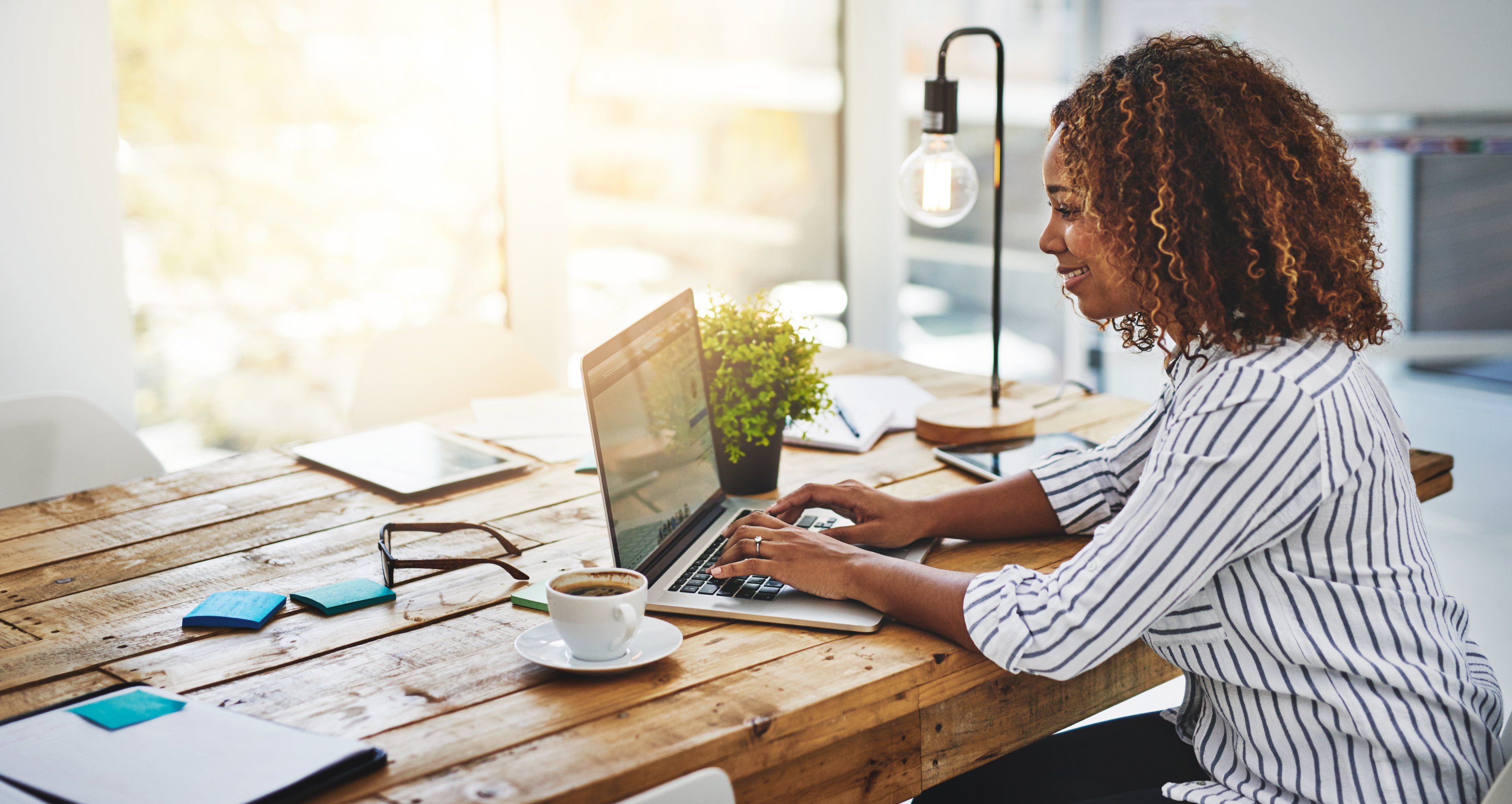 A woman types on her laptop