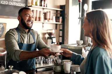 Male Barista Serving Customer