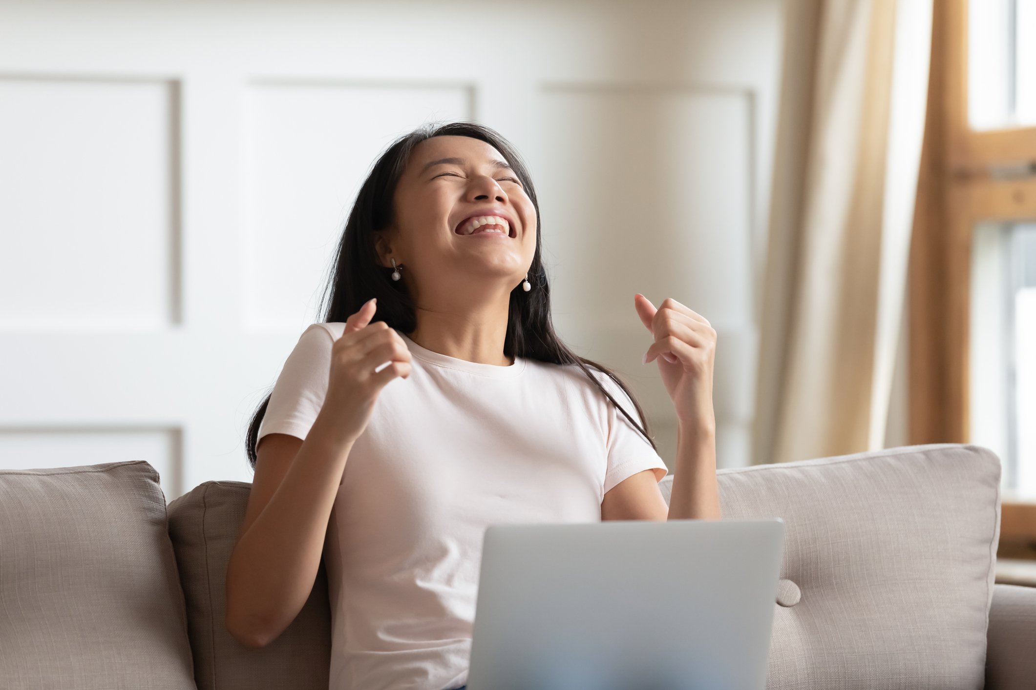 Person looking at a laptop celebrating.