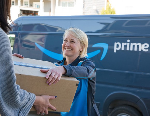 Worker delivering Amazon Prime package with a smile.