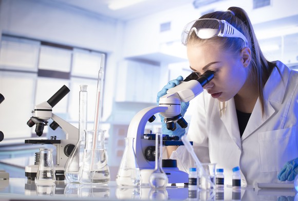 A scientist looking through a microscope.