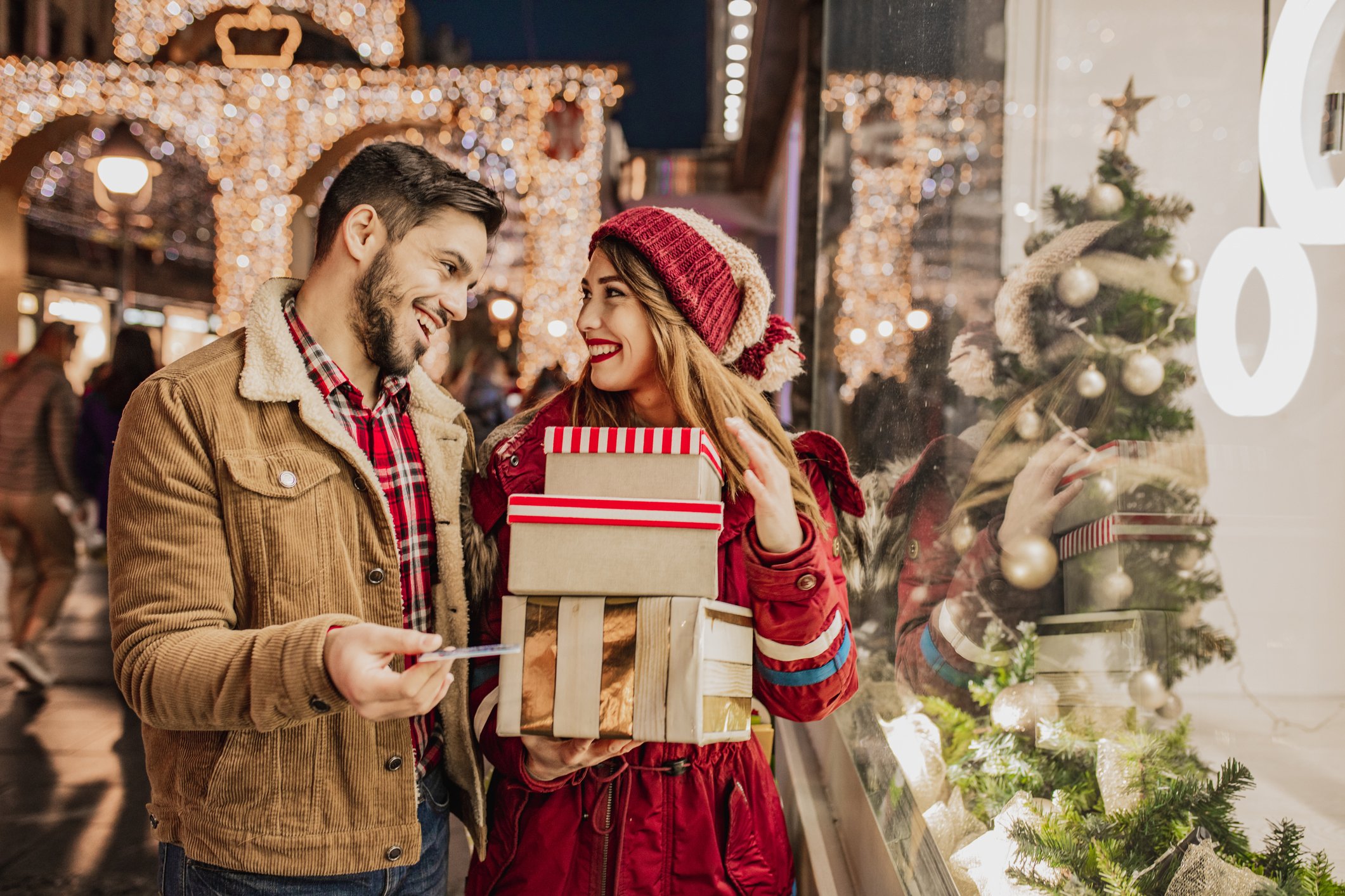Two smiling people holiday shopping.