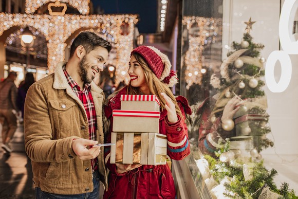 Two smiling people holiday shopping.