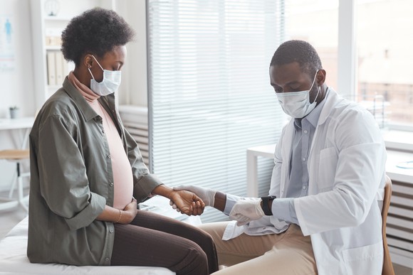 A pregnant patient is being examined by a doctor.