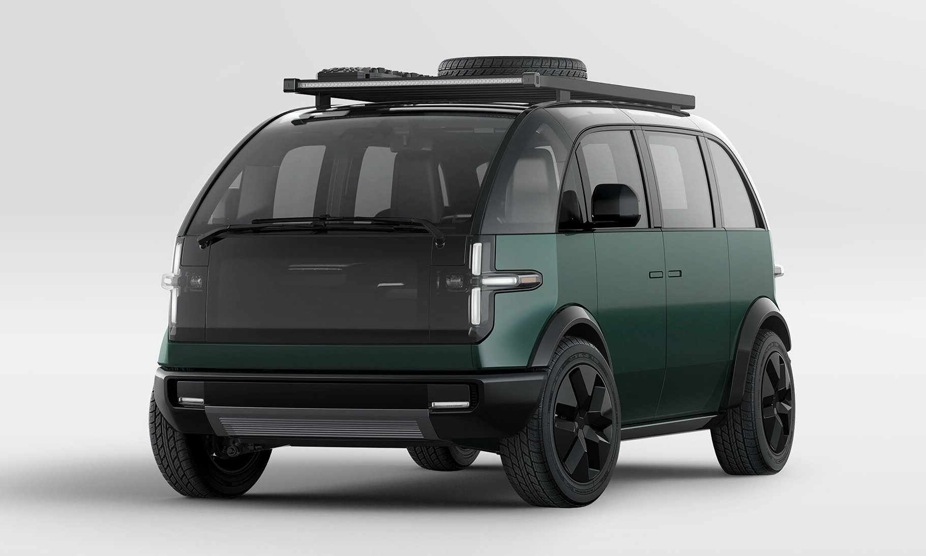 A green Canoo Lifestyle Vehicle, a small rugged-looking electric van.