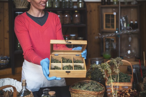A person holding a box of different cannabis strains in a cannabis store.
