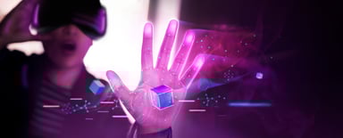 A person wearing VR goggles grabbing a cube.