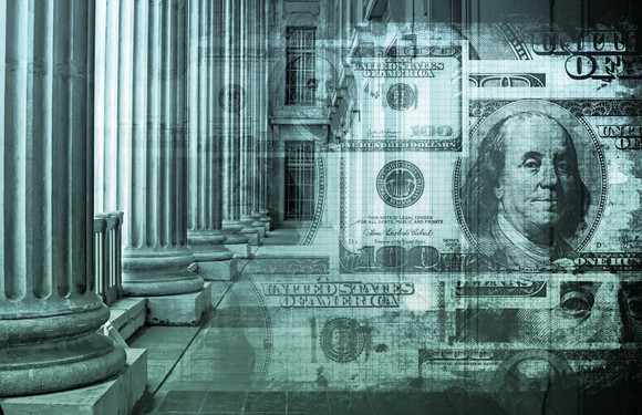 Images of 100-dollar bills are superimposed over roman columns from a federal building