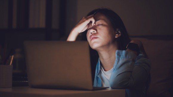 Stressed woman at a laptop.