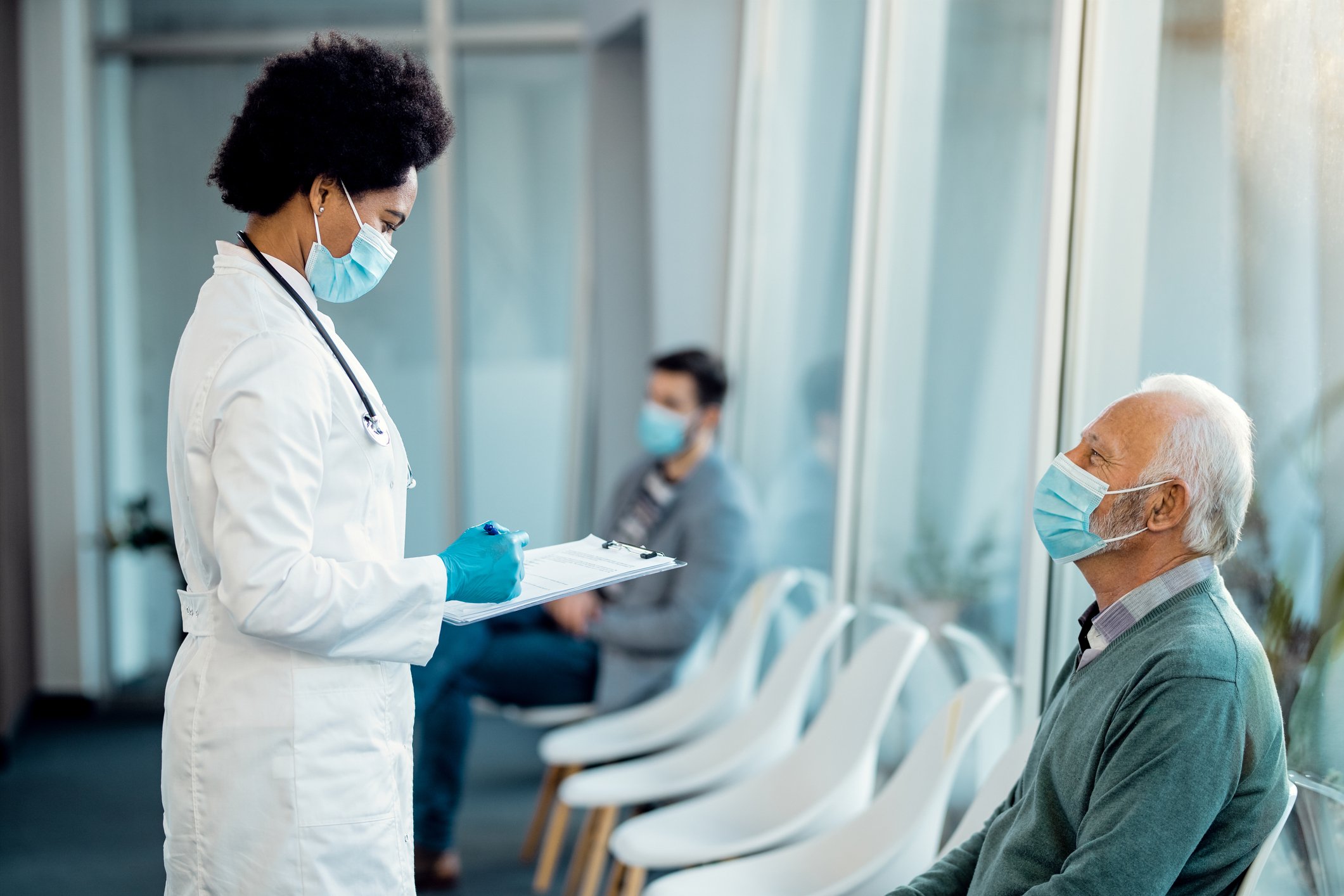 A doctor and patient interact in the waiting room.