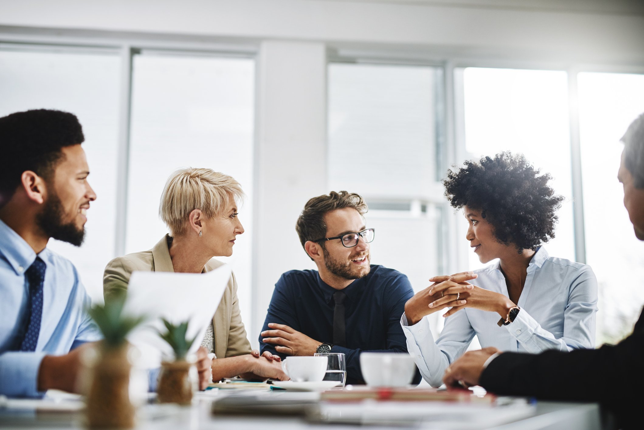 People sitting around a conference room table having a discussion.