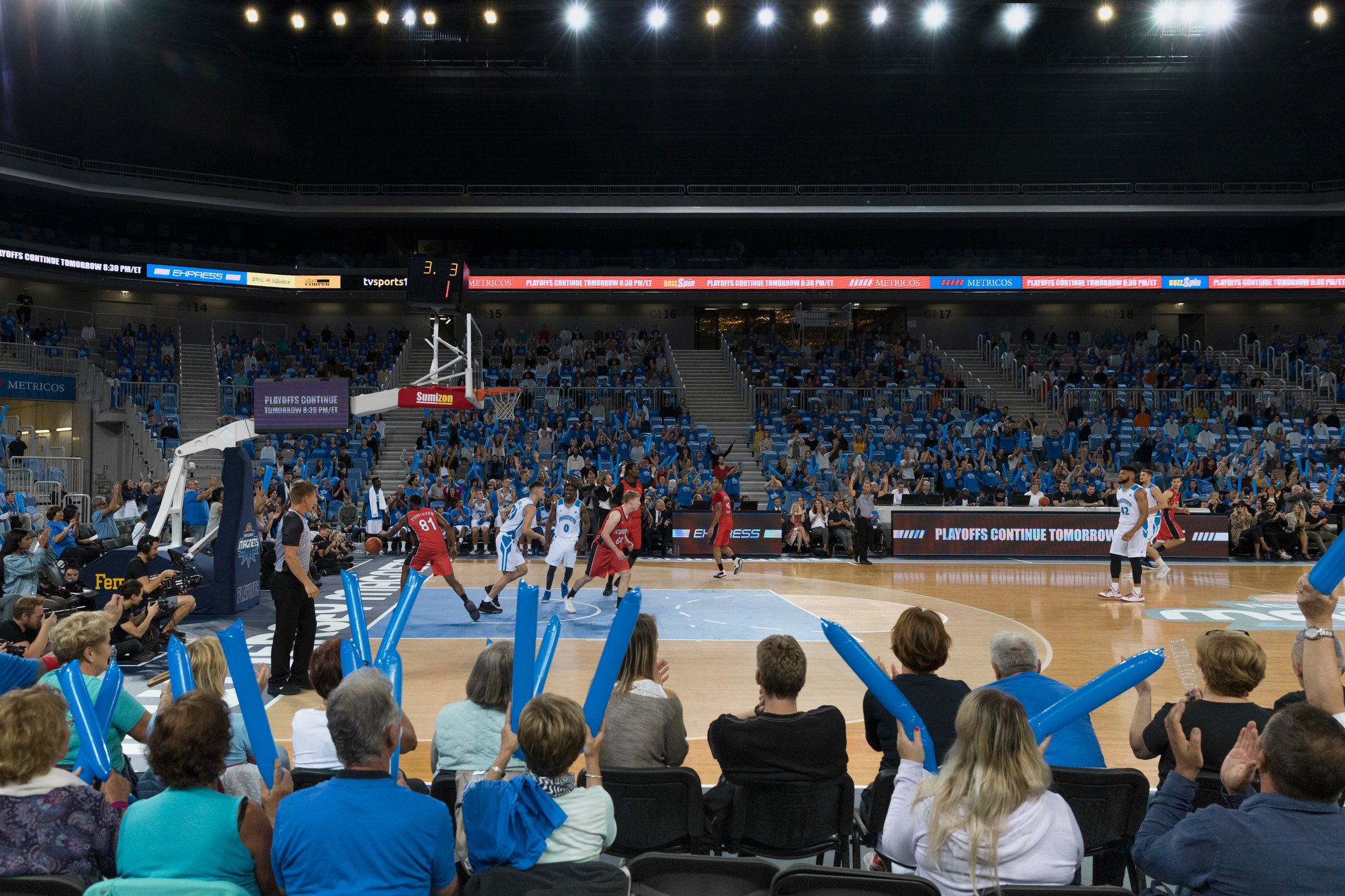 basketball game in arena filled with fans. 