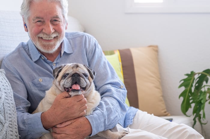 Smiling person holding dog.