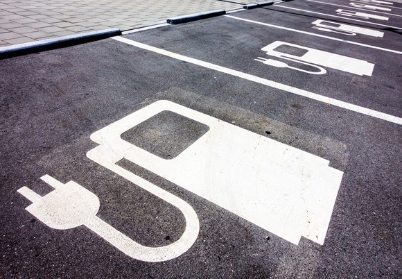 Symbols for electric vehicle charging are painted in parking spots. 