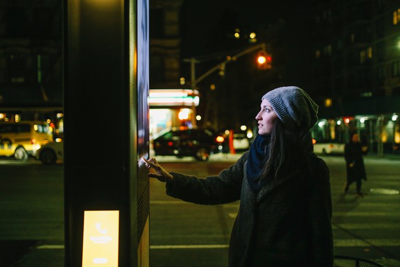 Someone using a digital kiosk in a city.