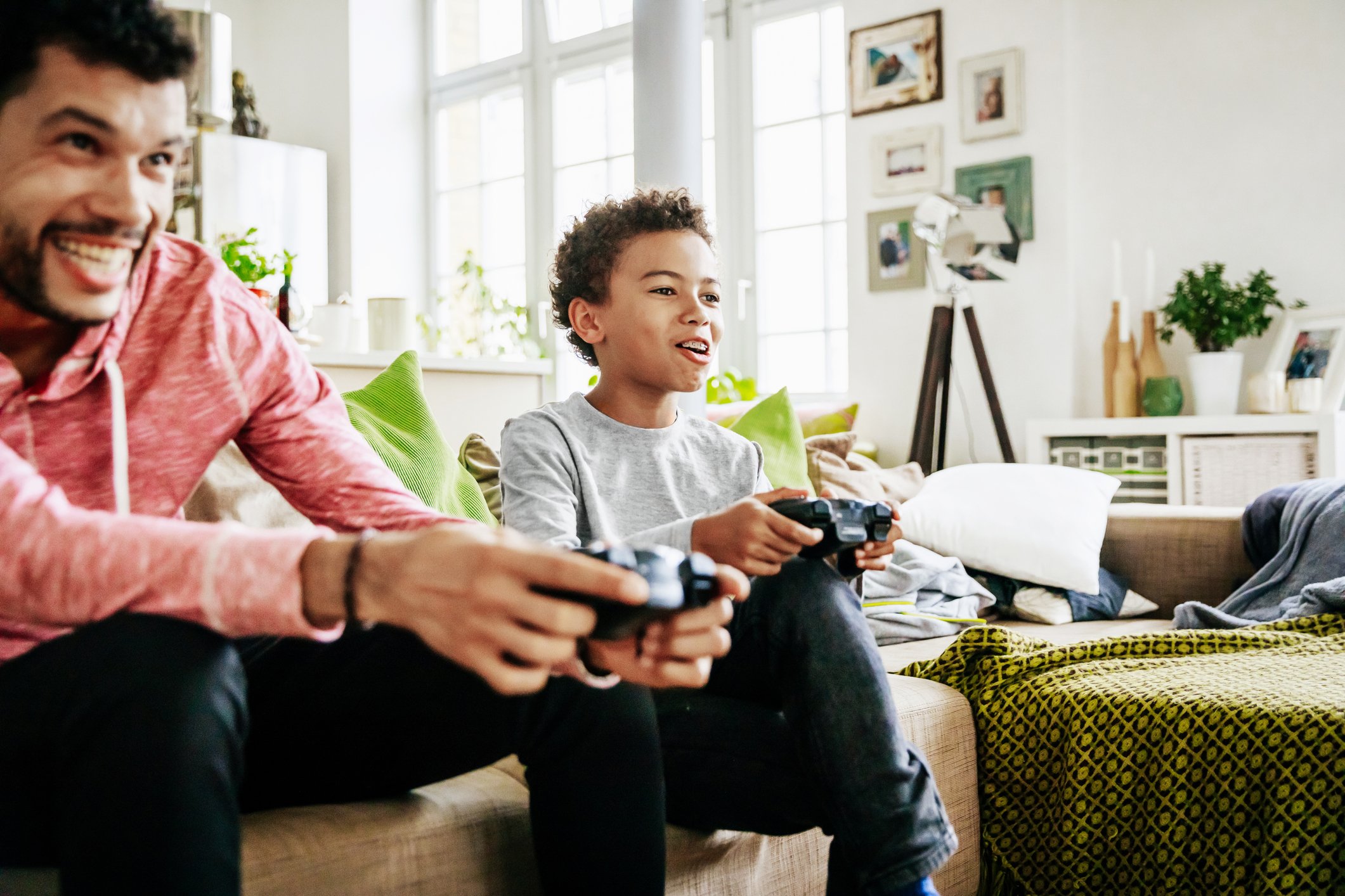 An adult playing a video game with a child.