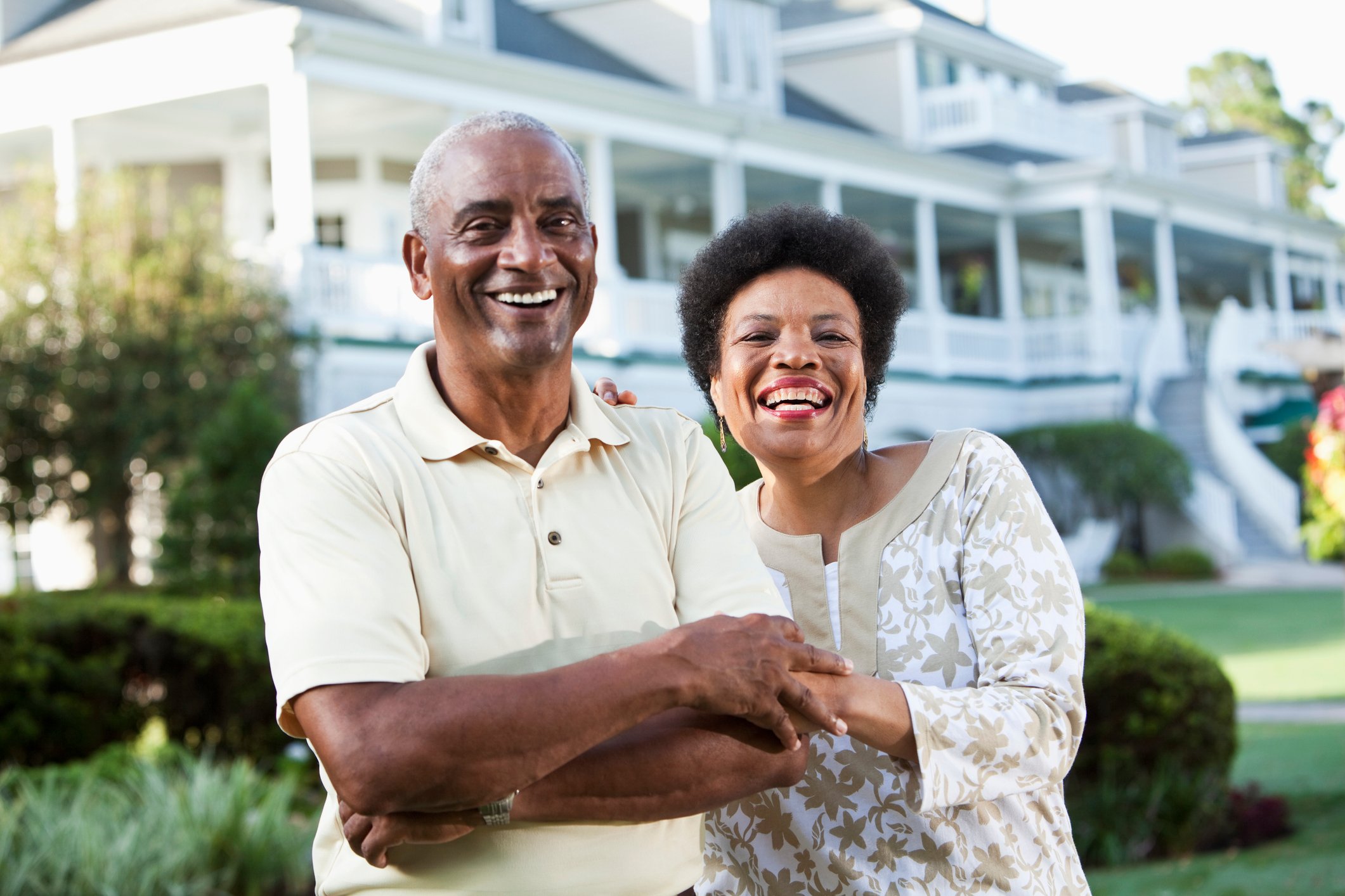 Two people standing in front of a house.