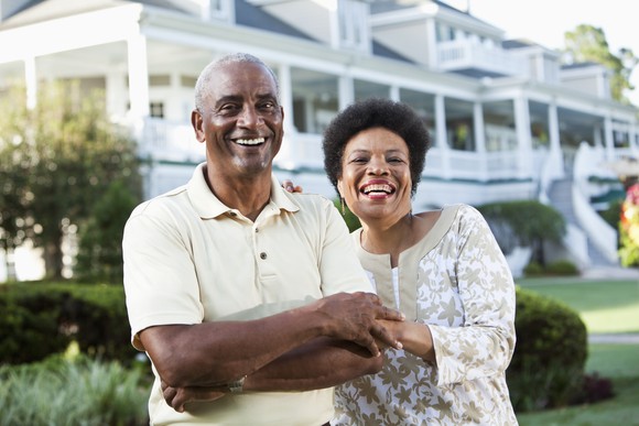 Two people standing in front of a house.