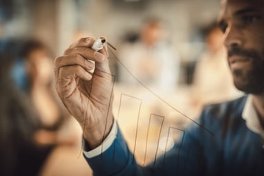 A person drawing an arrow on a chart.