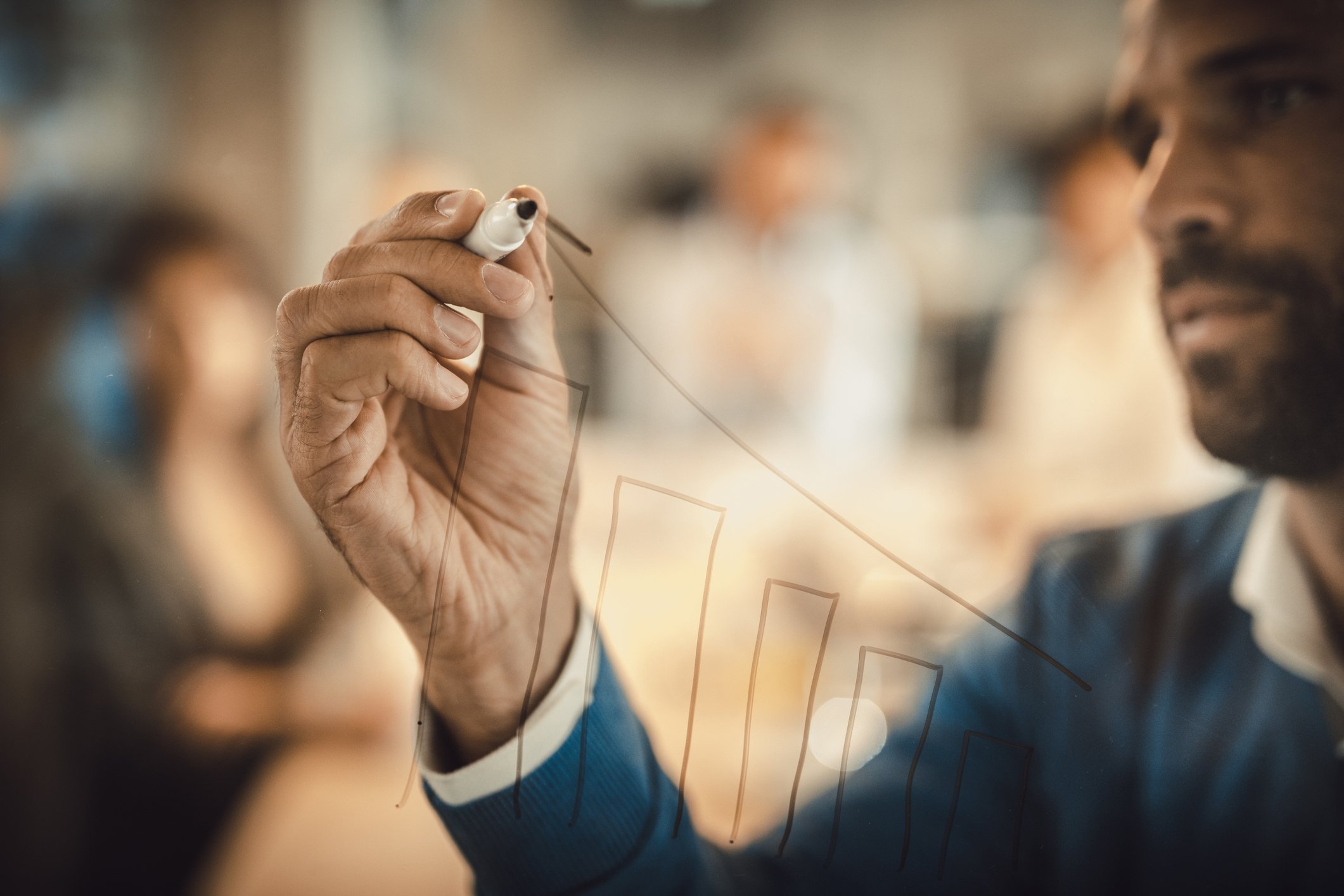 A person drawing an arrow on a chart.