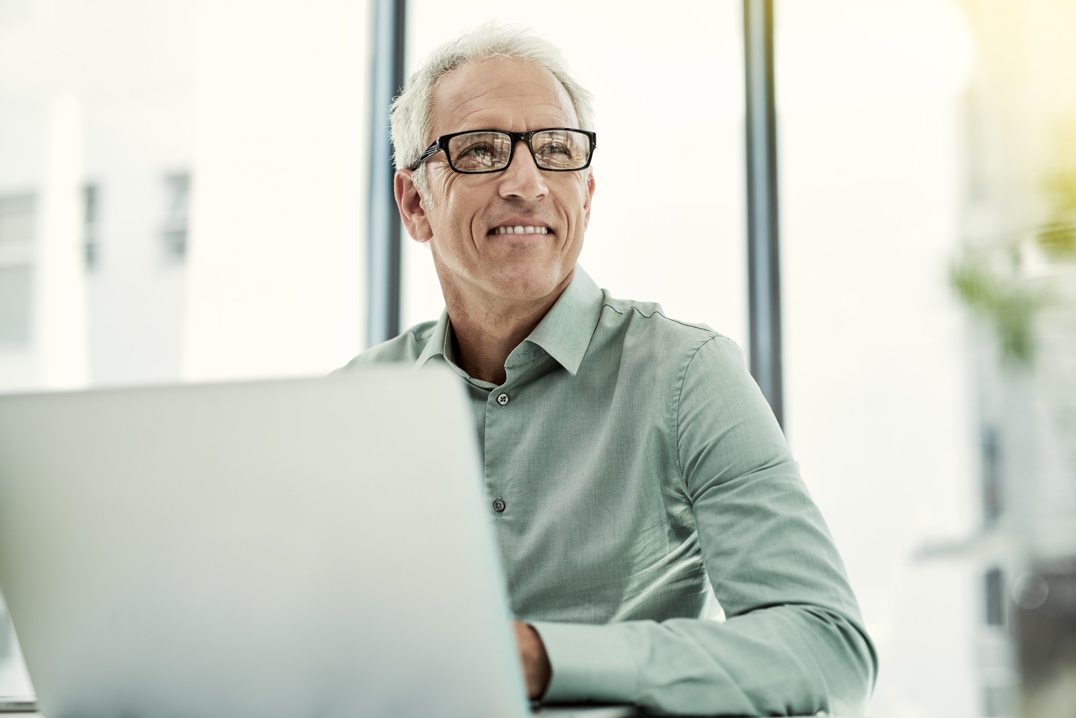 Smiling person at laptop.