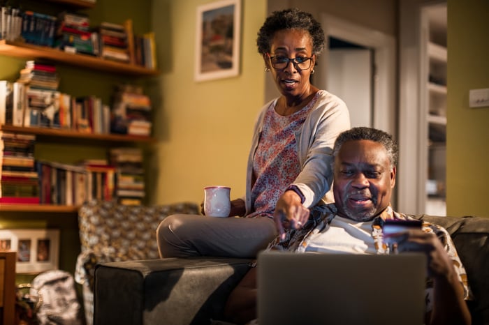 Two older adults looking at laptop.