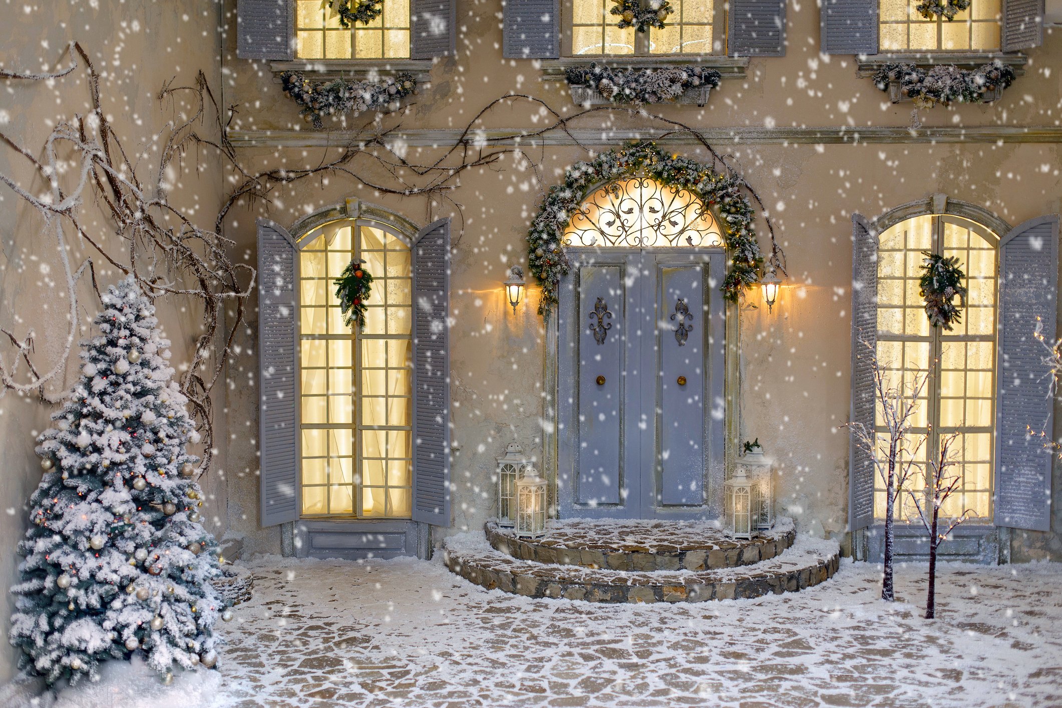 Snowy decorated home exterior at night.