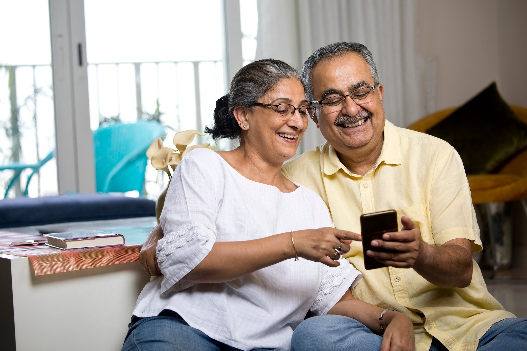 Two people looking at a smartphone and smiling.