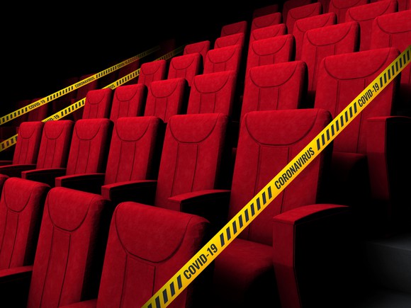 Theater seating closed by caution tape reading COVID-19 and coronavirus. 