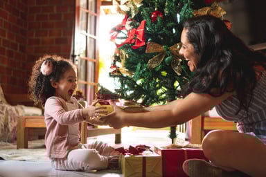 Person giving a gift to their child. 