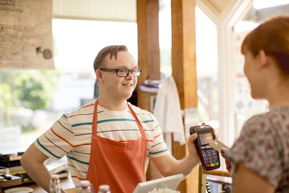 A cashier takes a card payment at a coffee shop.