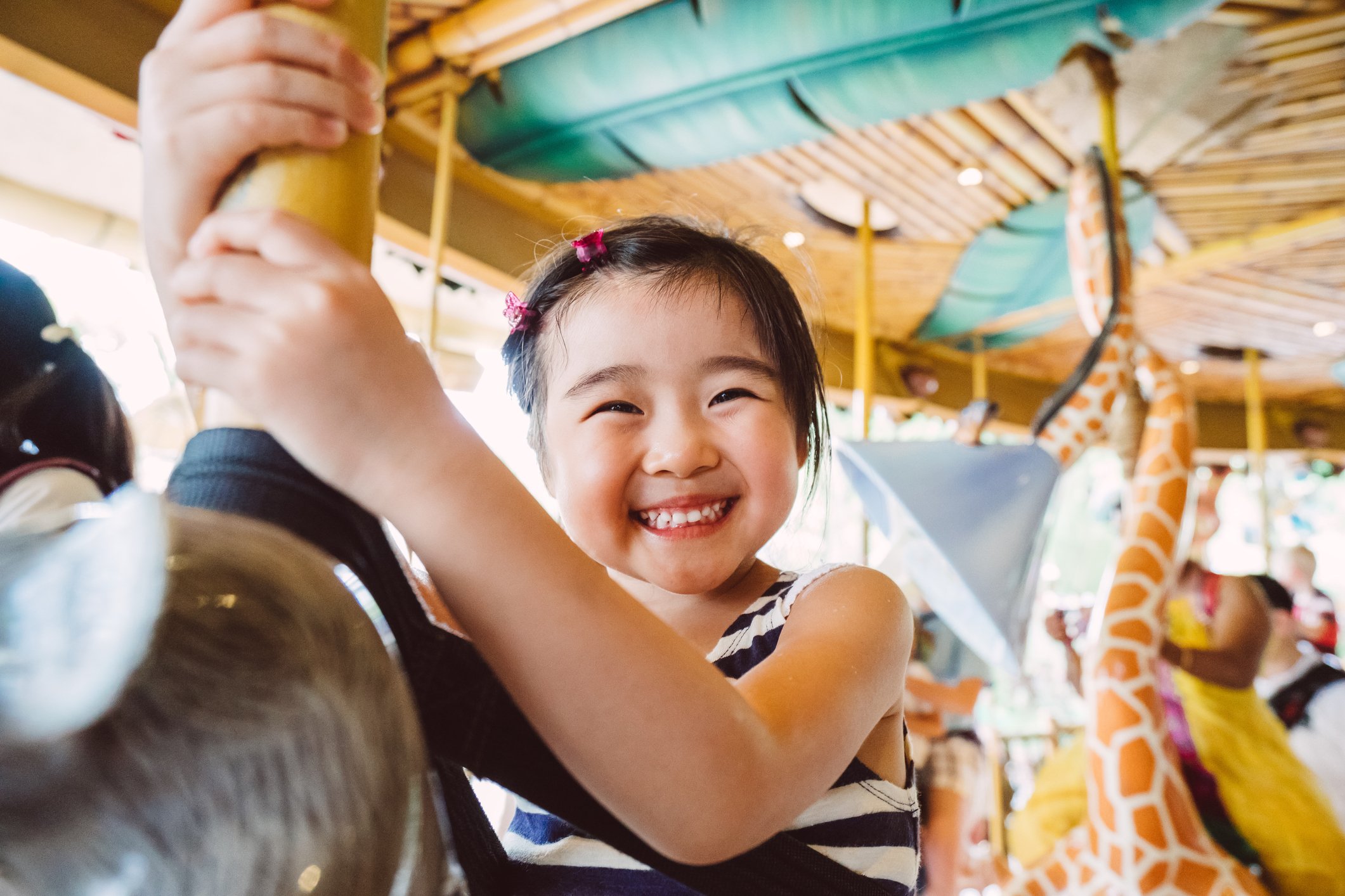 A young child riding on a carousel.