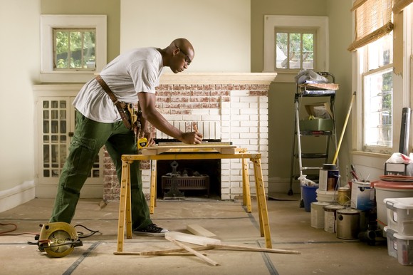 A person marks lumber for a cut during a house remodel.